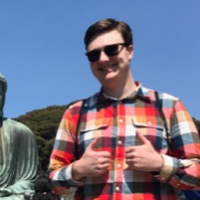 Jacob Vandever smiling in a flannel and sunglasses.