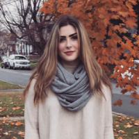 A portrait of Kalee Shomo standing in front of a tree with orange leaves