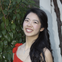 A headshot of a woman with black hair pulled to the side