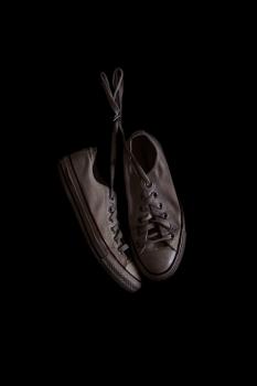 A pair of white Converse sneakers with a dark background