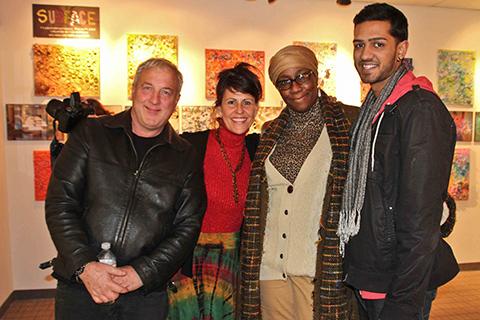 A group of four people standing in an art exhibit