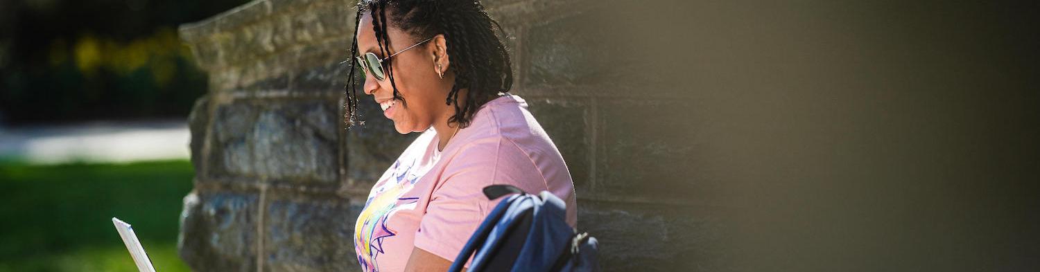 A student sitting with her laptop