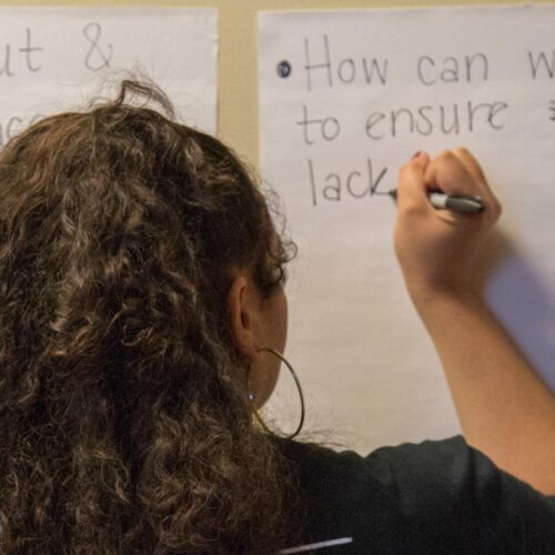 A student writes her opinion during "Being Black in a White Space" as part of the Break the Silence Workshop