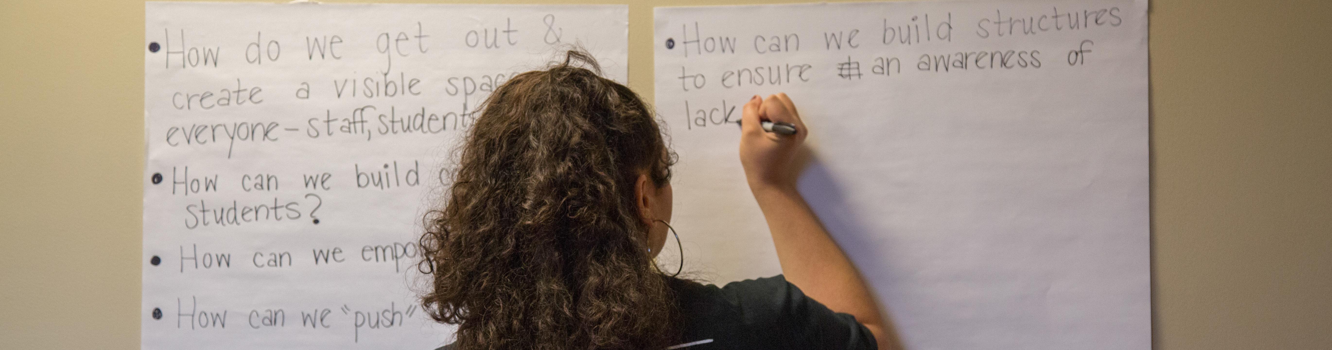 A student writes her opinion during "Being Black in a White Space" as part of the Break the Silence Workshop