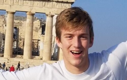 A student posing with old architecture from Greece.