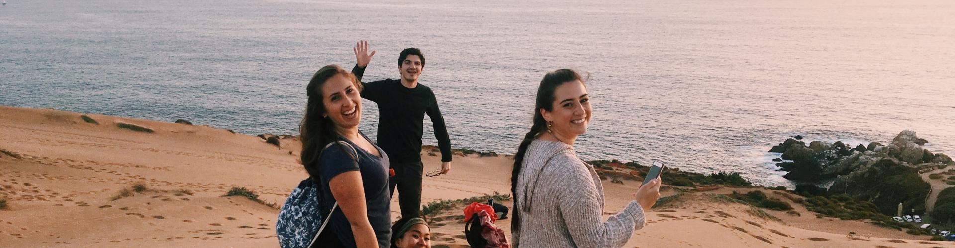 People smiling at the camera while on a beach side in Chile