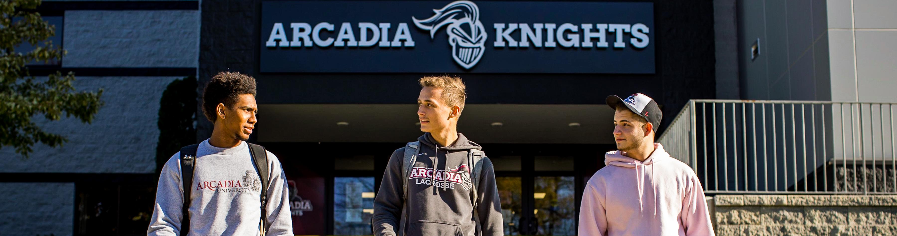 Three male students walk in front of Arcadia Kuch Center