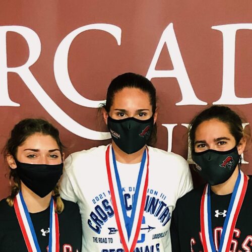 Three masked runners from Arcadia Women's Cross Country with medals around their necks.