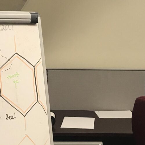 A sign that reads "Welcome to the Hive" on a whiteboard.
