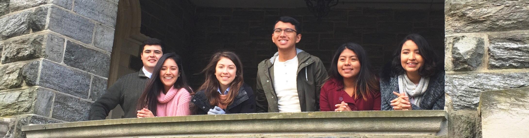Photo of smiling students standing on the covered patio of Grey Towers Castle.