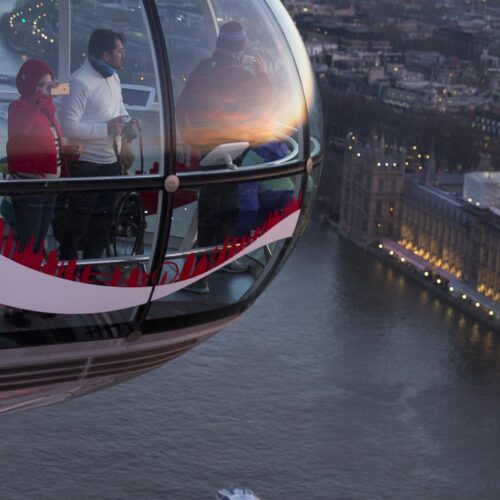 People in the London Eye ferris wheel looking over Parliament