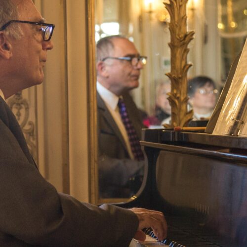 action shot off Samuel Heifetz playing the piano in the Mirror room