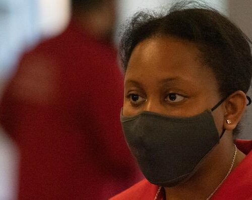 A faculty member wearing a mask at an open house event.