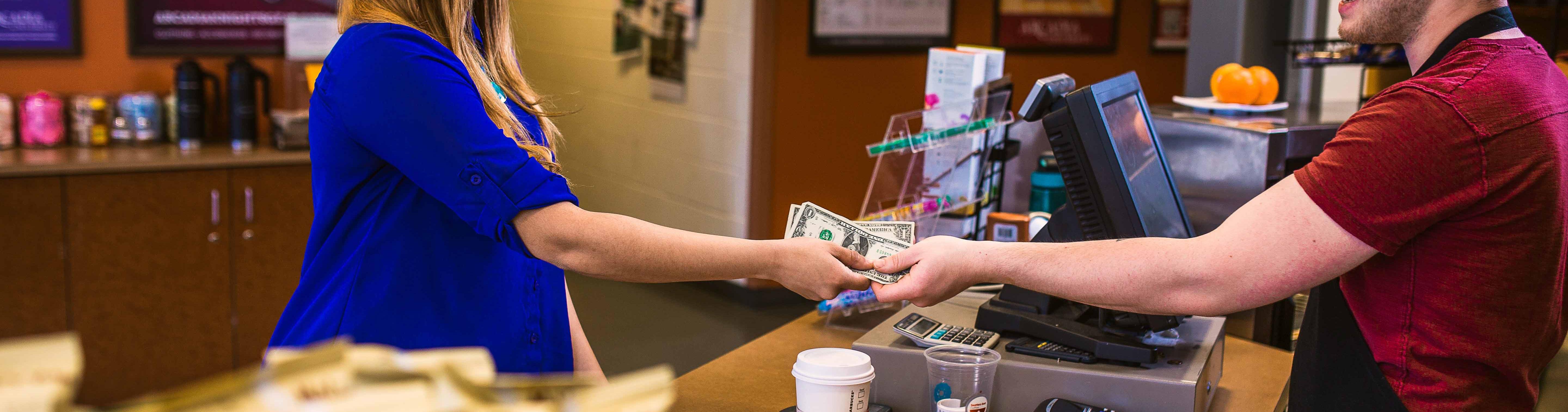 Two people exchanging money at a register.