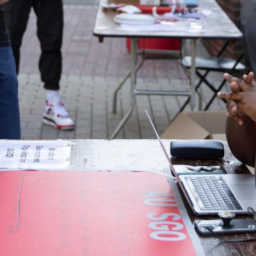 A man sitting at a table on the Walk of Pride