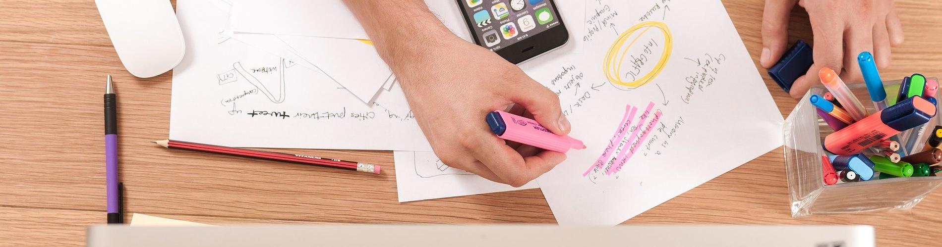 Stock imagery of someone highlighting a paper.