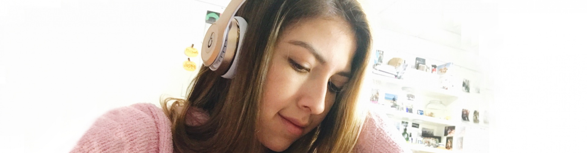 A girl with headphones on, looking down.