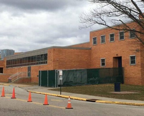 exterior shot of a high school with buses outside