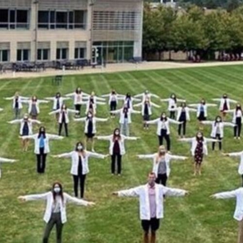 Physician assistant students standing six feet apart from each other while wearing masks.