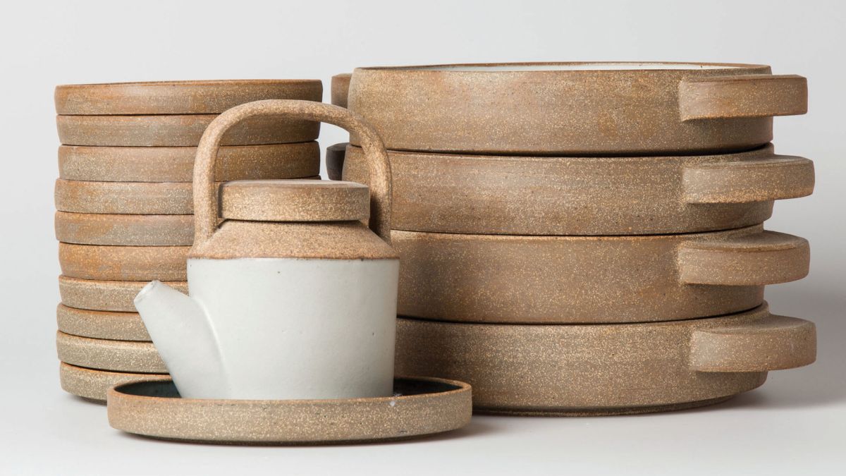 White tea pot with brown plates behind the tea pot
