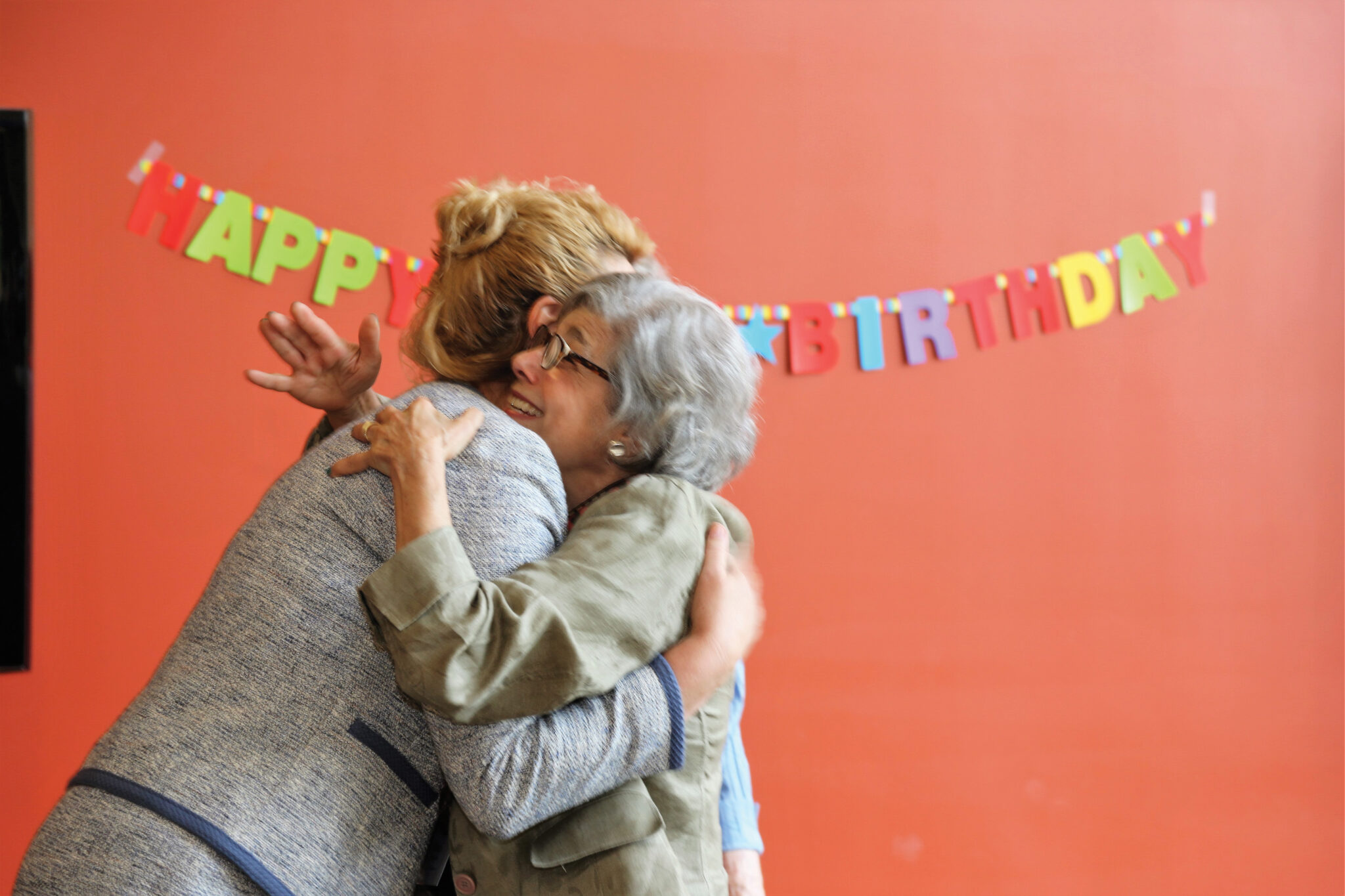 Two people hugging each other during a birthday celebration