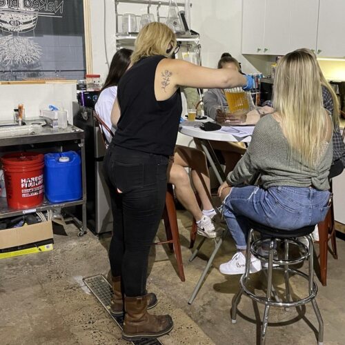 A group of women with one pouring a beer for them all
