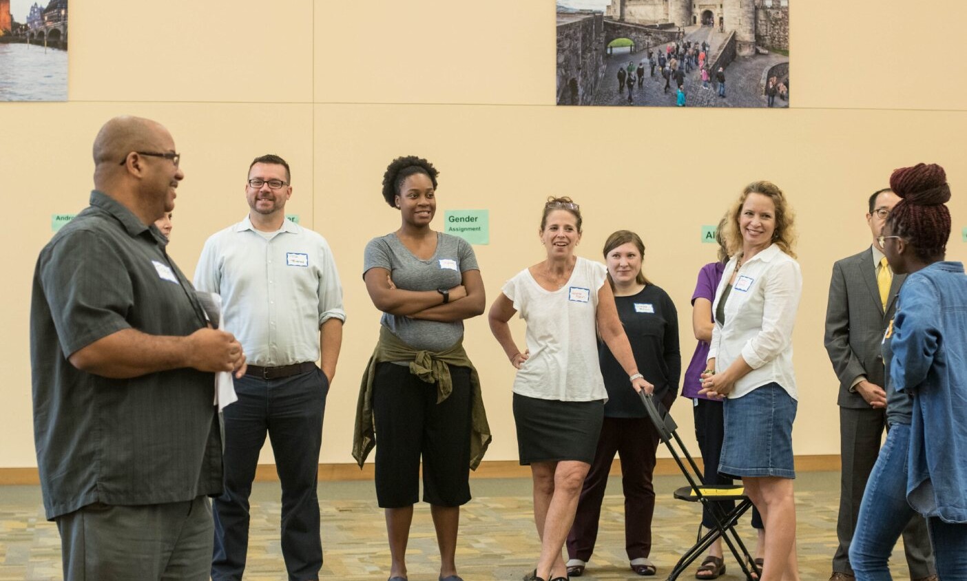 Educators stand in a circle and smile