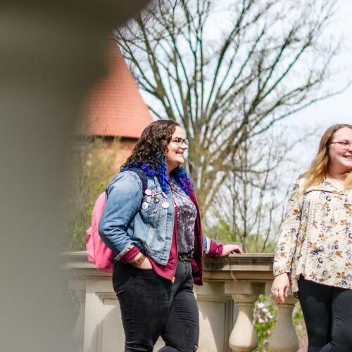 Three female students talk outside on Arcadia University campus