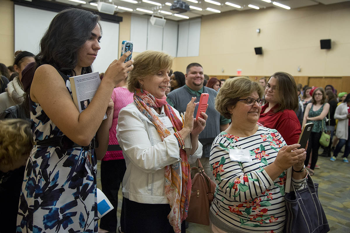 People taking photos with their phones at a book signing event