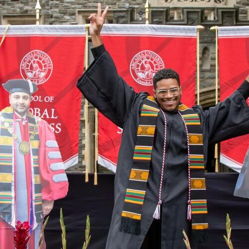 A student crosses the stage at a social distance graduation