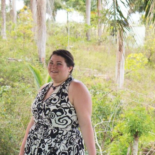 Two people smiling and laughing with a tropical grassland-like background