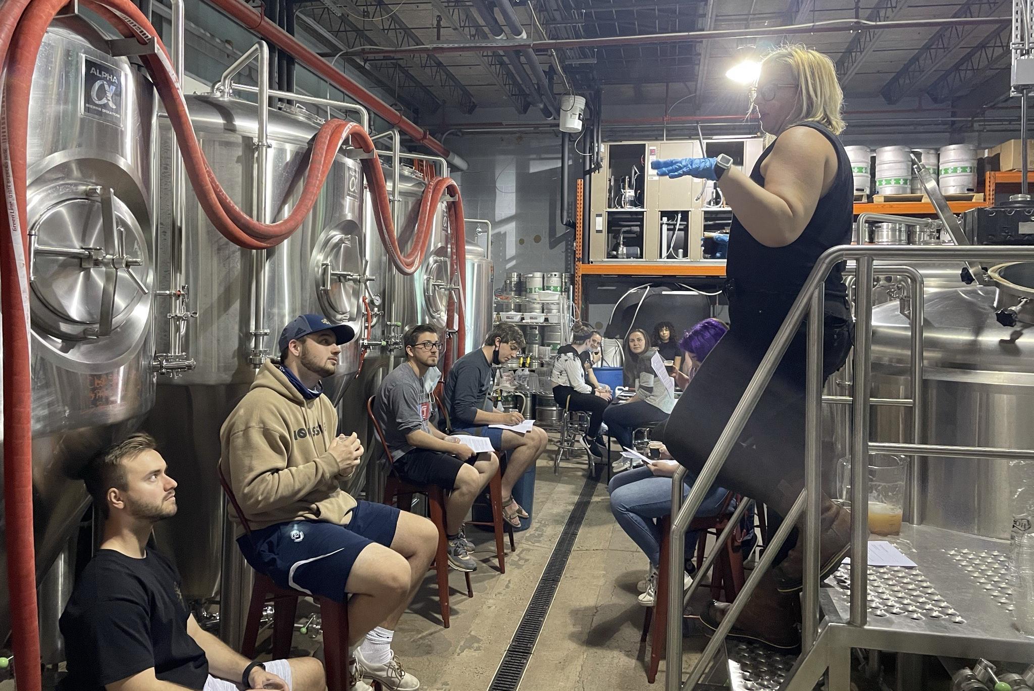 A guest speaking to students during the brewery trip