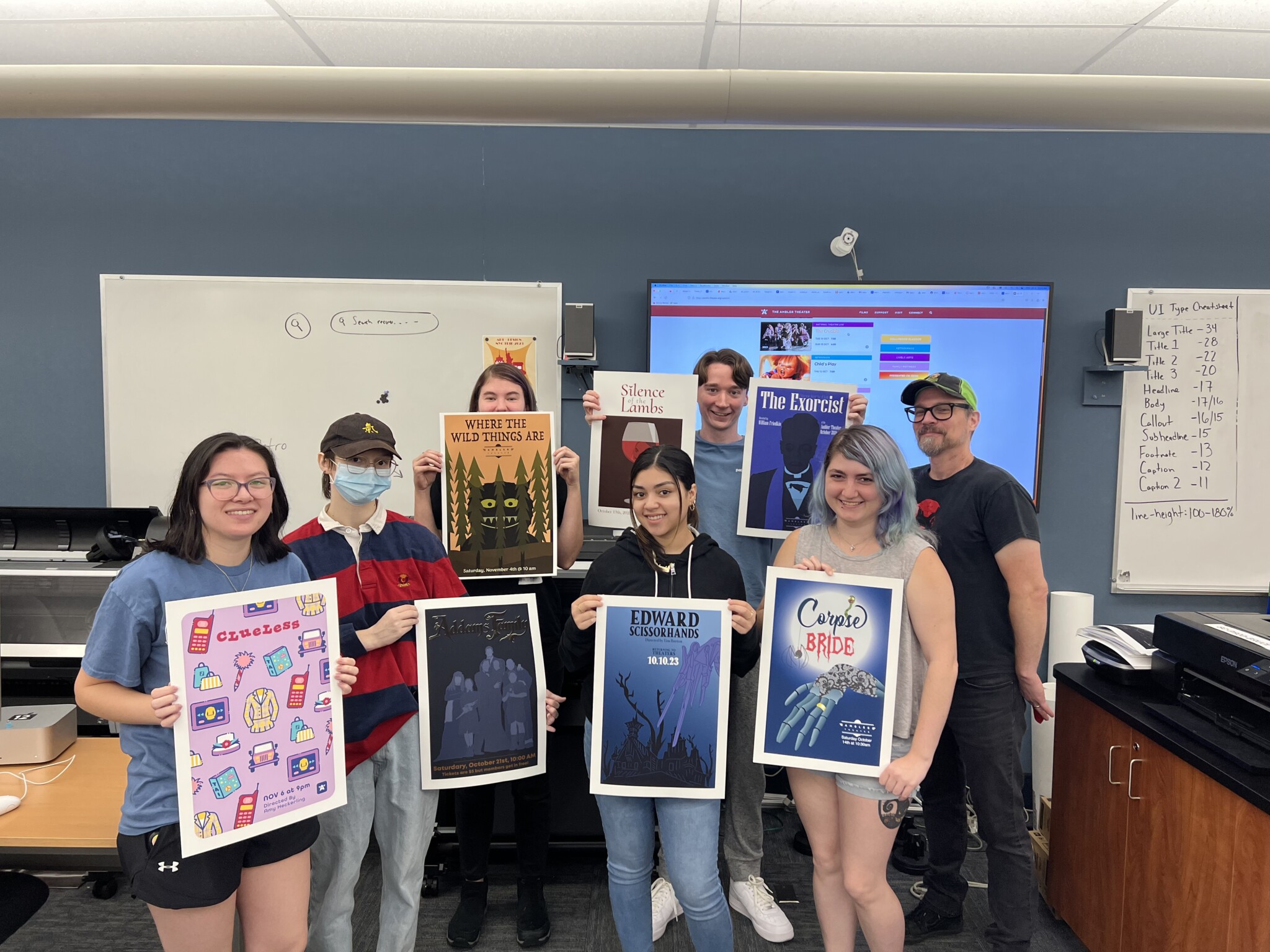 Students holding their movie posters up in the air