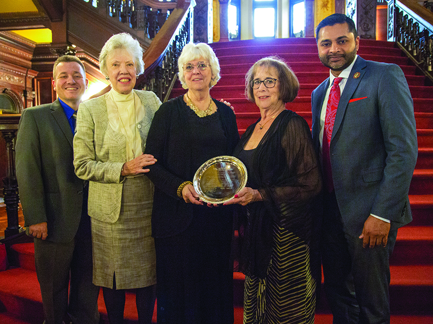 President Nair posing with a alumni holding a plaque award