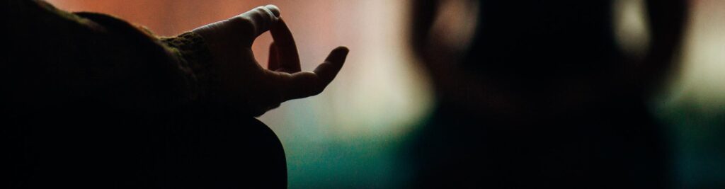 A photo of a hand in the shadow in a meditative pose