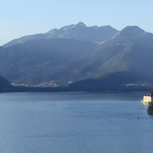 A large body of water with grassy mountains in the background