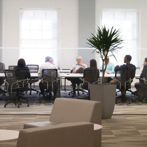 wide shot of people at a meeting a a long table