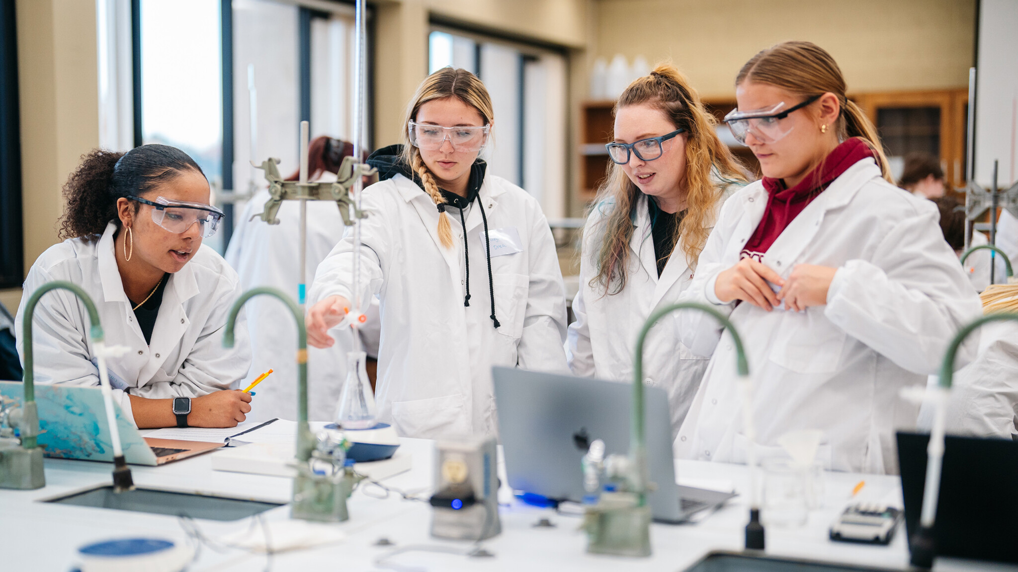 Students work with test tubes, vials, and computers in a chemistry lab at Arcadia University.