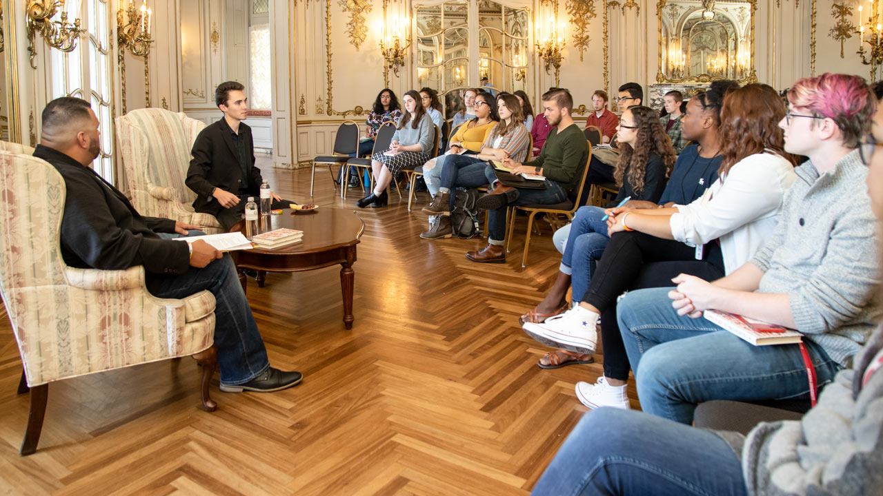 Civic scholars listen to a presentation from an author.