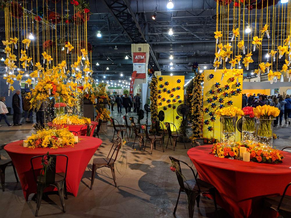 Red table settings with yellow flowers as center pieces.