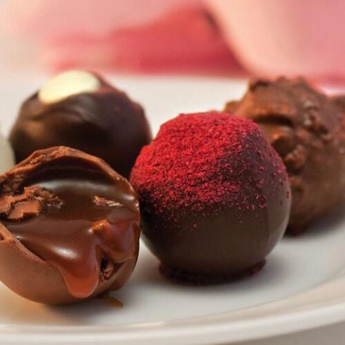 A variety of chocolate truffles served on a plate