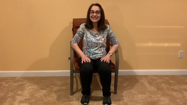 seated woman prepares for Tai Chi warm up