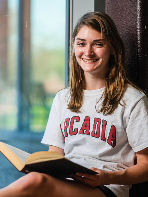 Micah Gordley reads a book by the window.