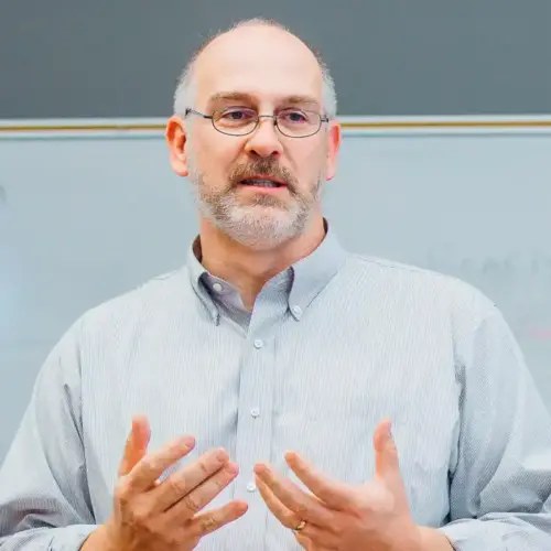 The headshot of John A. Noakes while teaching a class