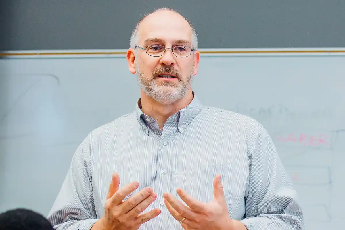 The headshot of John A. Noakes while teaching a class