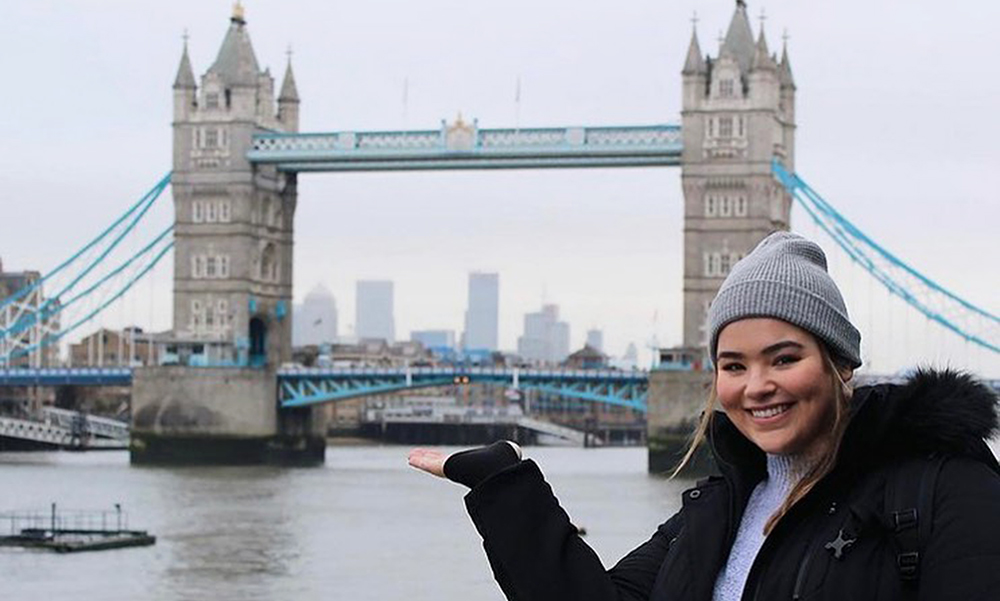 An Arcadia student poses by London Bridge.