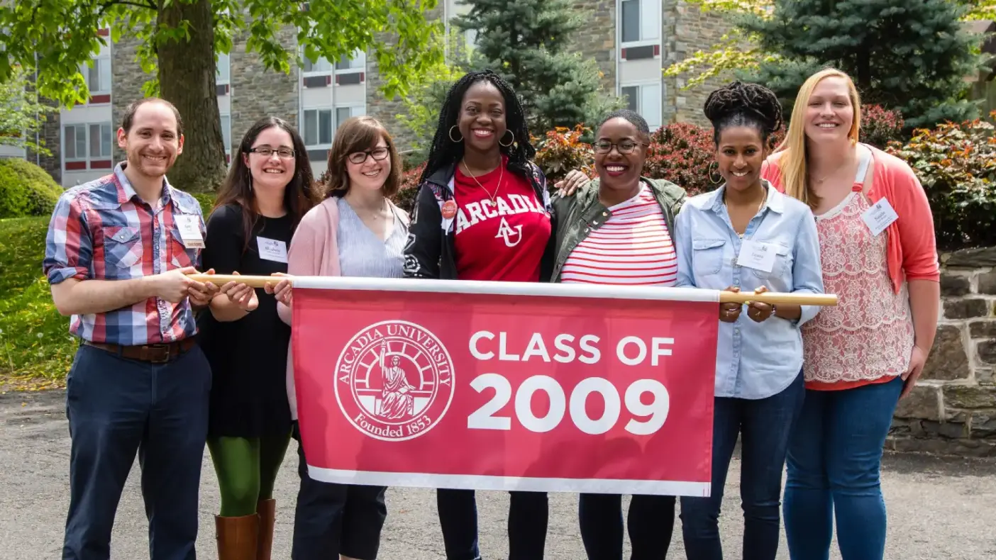 Class of 2009 students gather around a banner that reads "Class of 2009".