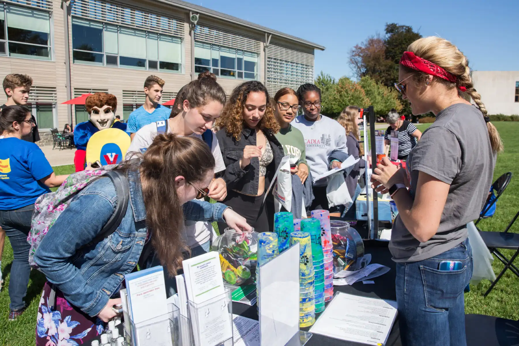 Several students listening to a speaker at a table.