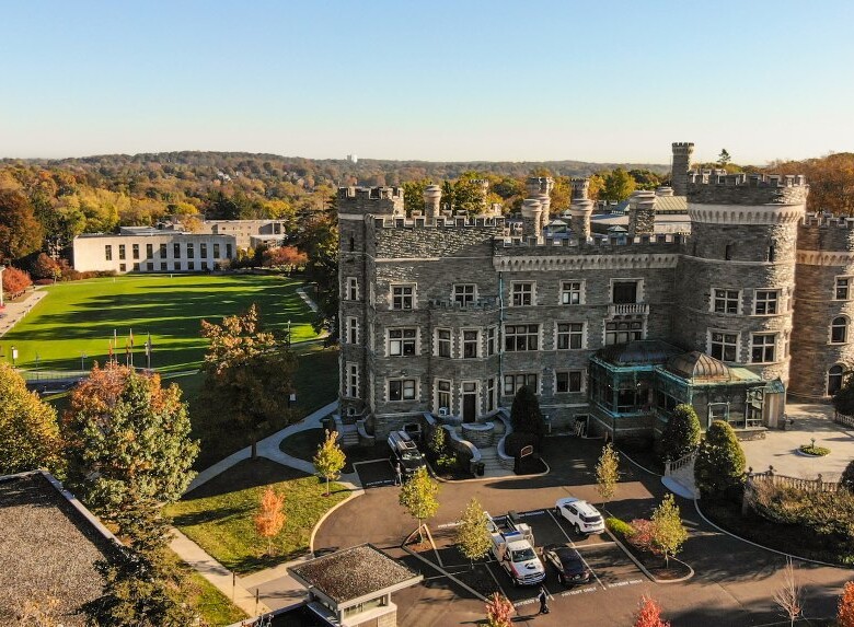 An aerial view of Grey Towers with fall color leaves surrounding the landscape.