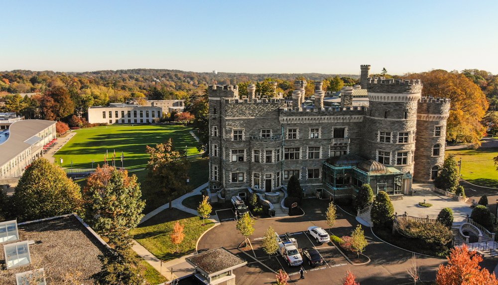 An aerial view of Grey Towers with fall color leaves surrounding the landscape.